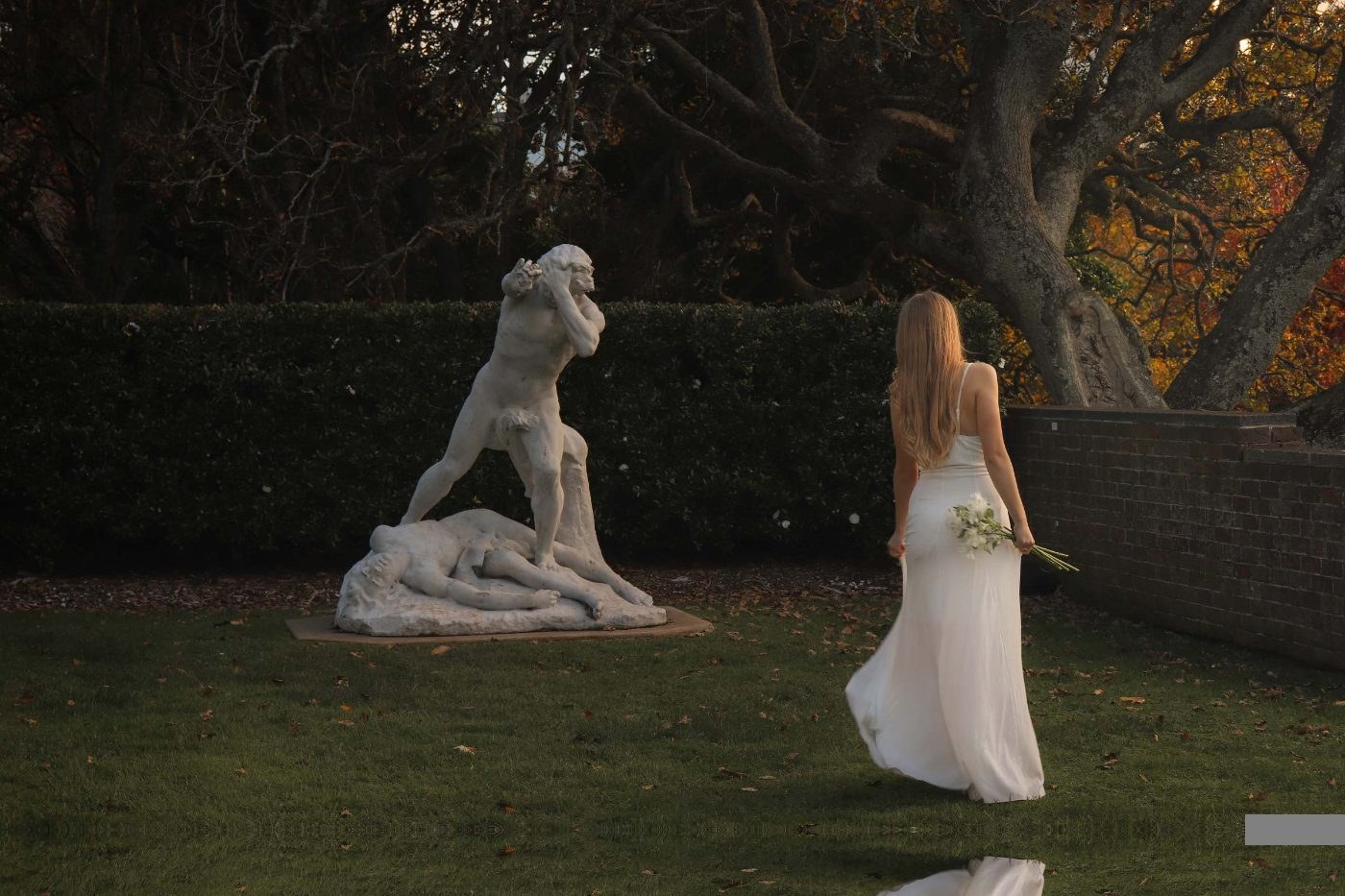 A bride walking through a golden-hour garden