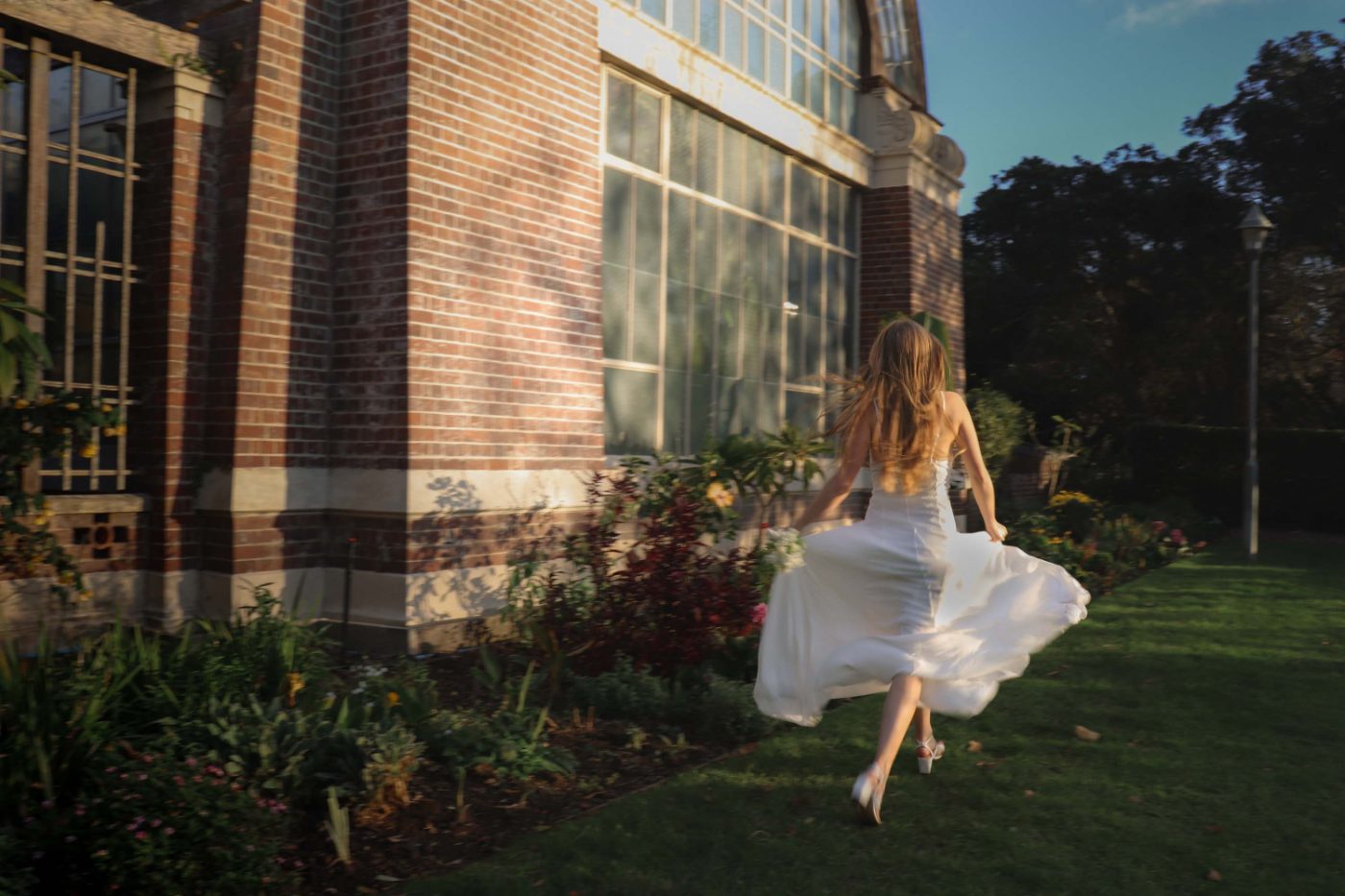 A bride mid-air outside a brick building