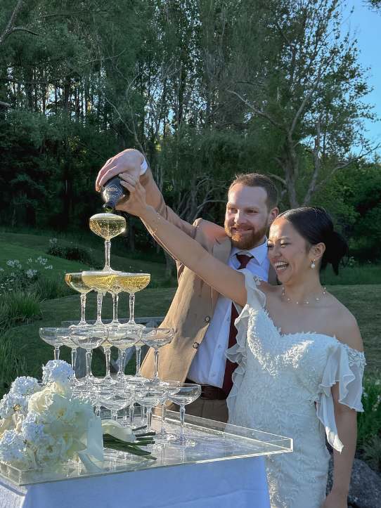 A couple pouring a champagne tower