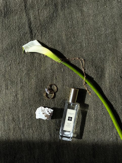 A calla lily and fragrance flatlay